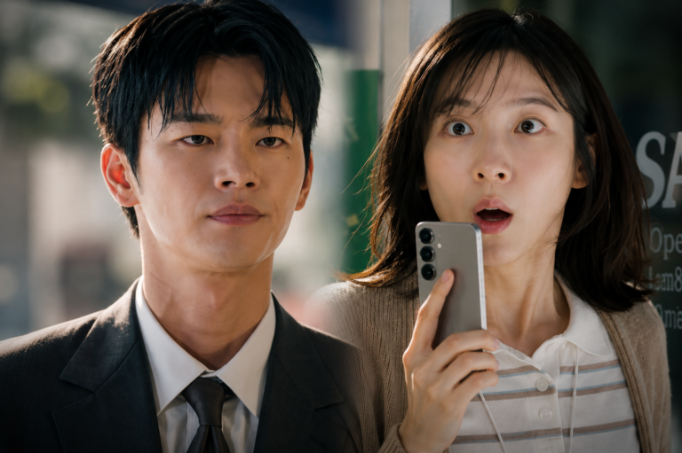 Seo In-guk como Kang Si-woo de terno e Park Ji-hyun como Cha Ji-yoon com expressão de choque ao telefone em Te vejo no trabalho