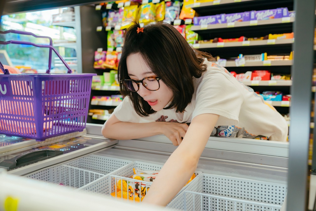 Park Ji-hyun como Cha Ji-yoon se inclina sobre freezer de sorvetes em loja de conveniência em Te vejo no trabalho!