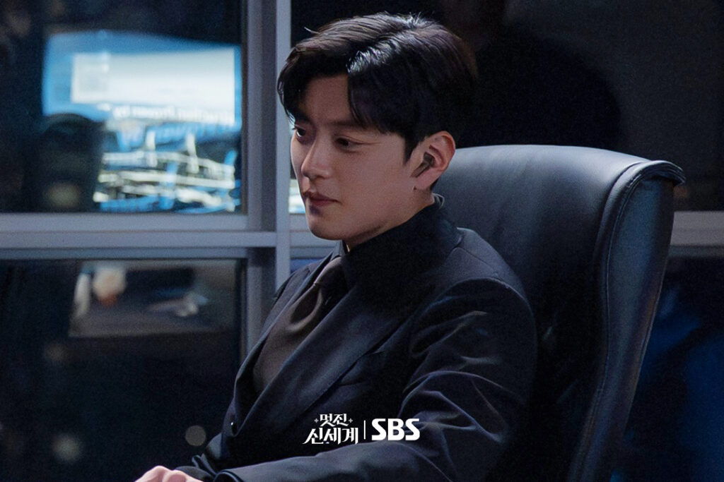 Jang Seung-jo como Choi Mun-do em terno preto em escritório escuro em cena de My Royal Nemesis