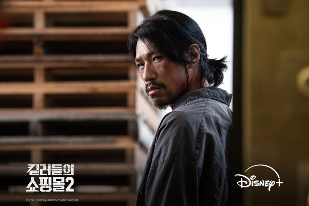 Kim Min como Pasin com cabelo longo e cicatriz no rosto em Uma Loja Para Assassinos 2