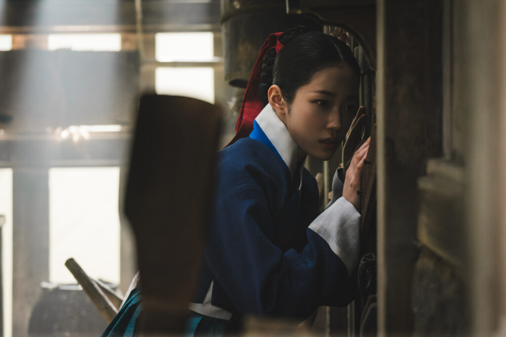 Roh Yoon-seo como Saeng-gang ouve atentamente sons invisíveis em cena de A Leste do Palácio