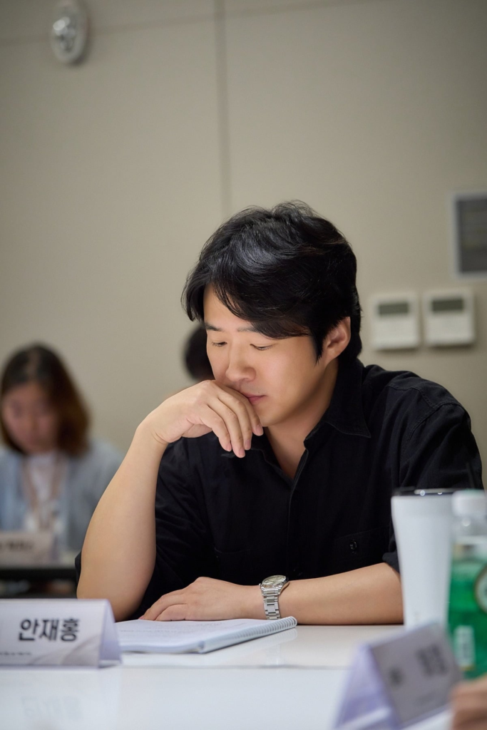 Ahn Jae-hong pensativo durante a leitura de roteiro de Dia Sem Maus Espíritos