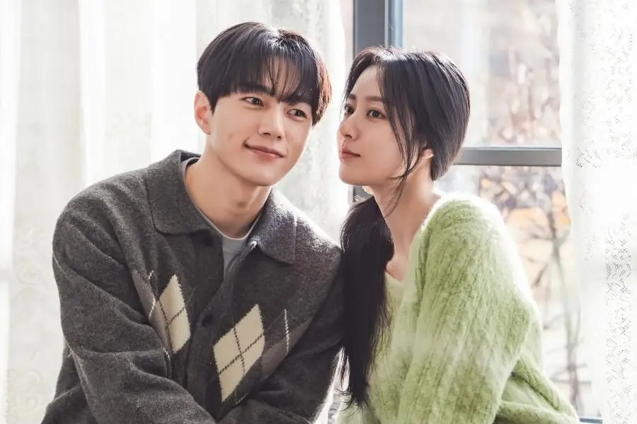 Kim Myung-soo e Kang Min-ah sentados próximos perto de uma janela com cortinas claras em still de Amor em Sincronia