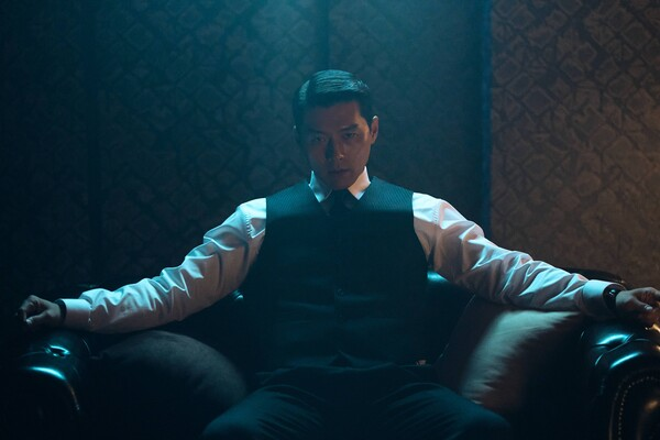 Hyun Bin como Baek Kitae sentado em ambiente escuro em Made in Korea 2